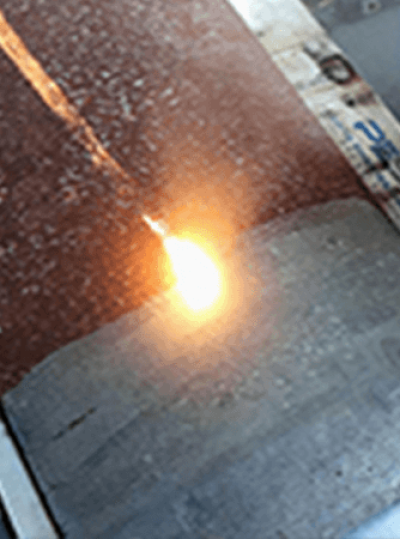 Laser cleaning rust off a metal surface, showcasing laser rust cleaning machine